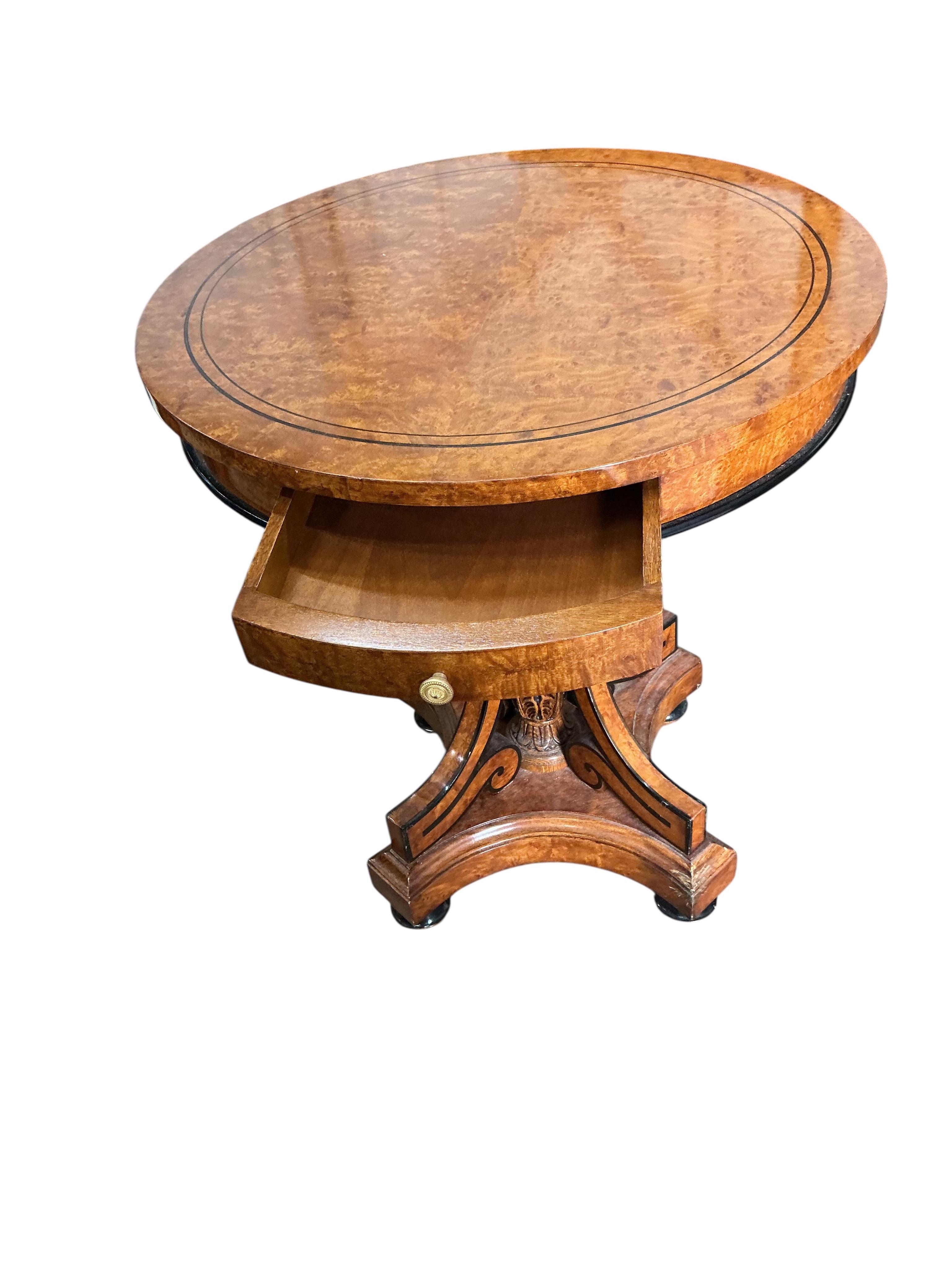 A Regency style part ebonised bird's eye maple circular centre table, diameter 64cm, height 74cm
